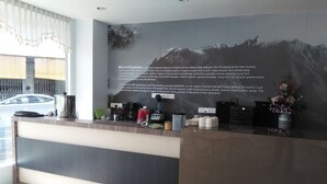 En hotellreception med en stor informationsskärm som visar information om berget Mount Kinabalu, en bergstopp av granit i Sabah.