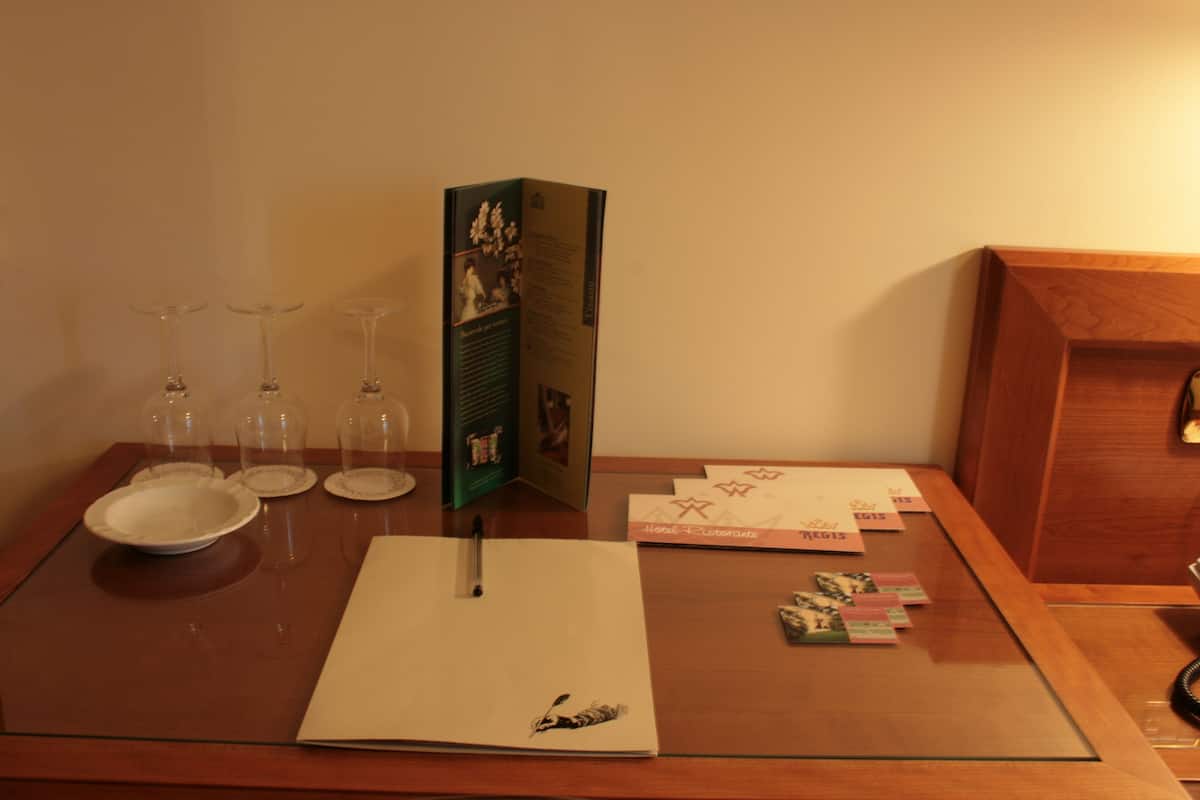 Une table avec un menu, un stylo, un verre et une assiette.