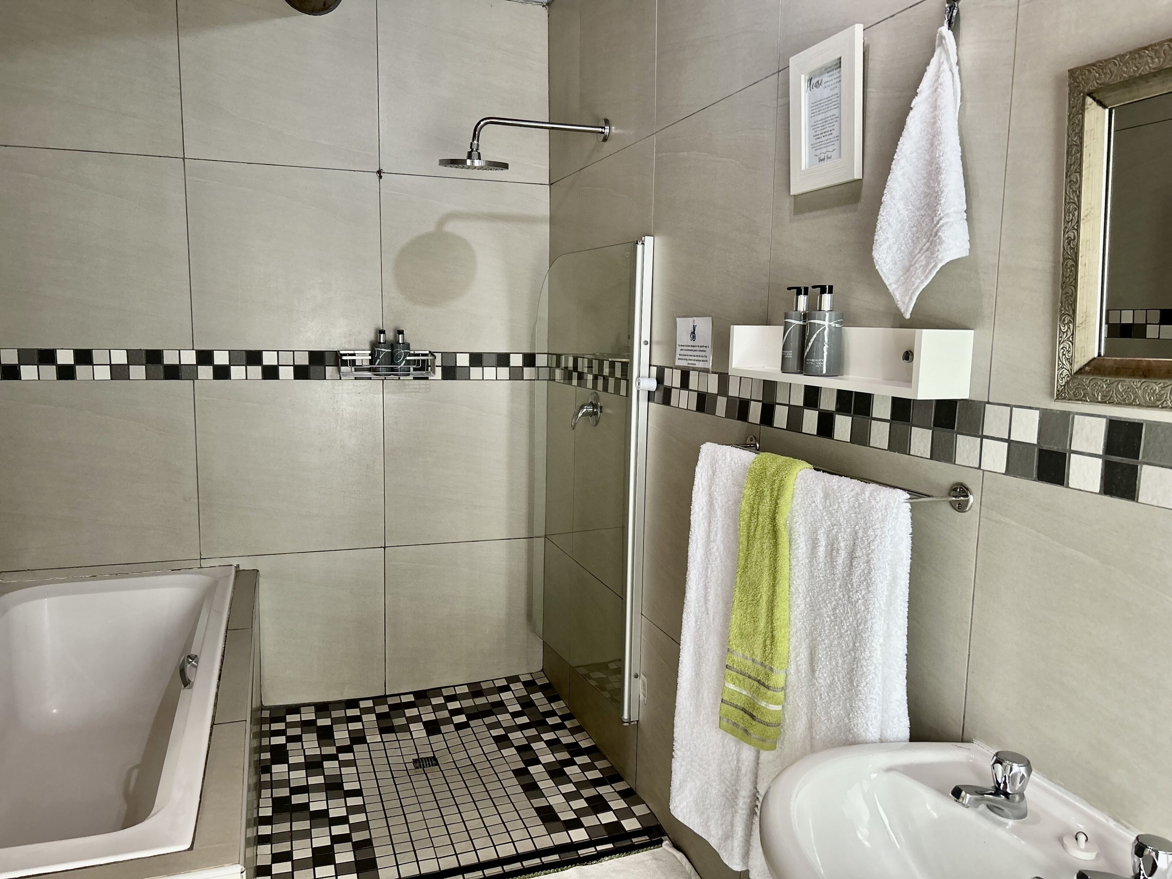 A modern bathroom with a bathtub, shower, and sink.