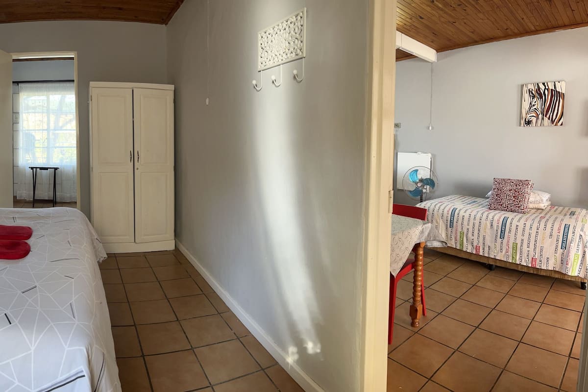 A bedroom with a bed, bedside table, lamp, wardrobe, and a mirror.