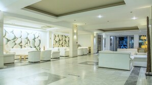 A spacious lobby with a checkered floor, white sofas, and a wall with a geometric pattern. - Semiramis Village (Hersonissos)