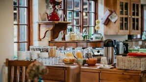 A kitchen with wooden cabinets, a coffee maker, and various kitchen utensils. - The Village Lodge (Storms River)