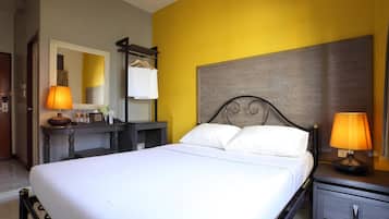 A hotel room with a bed, bedside tables, a desk, and a mirror.