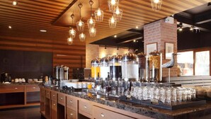 A bar area with a long counter, multiple beverage dispensers, and hanging light fixtures. - Rambuttri Village Inn & Plaza (Bangkok)