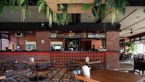 A restaurant with a brick counter, multiple tables, and chairs. - Rambuttri Village Inn & Plaza (Bangkok)