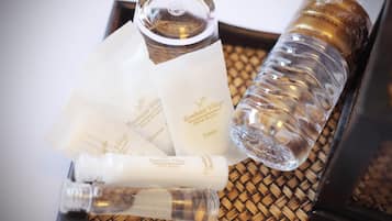 A tray with various toiletries including a bottle of shampoo, a bottle of conditioner, and several bars of soap, all branded with 'Rambutti Village'.