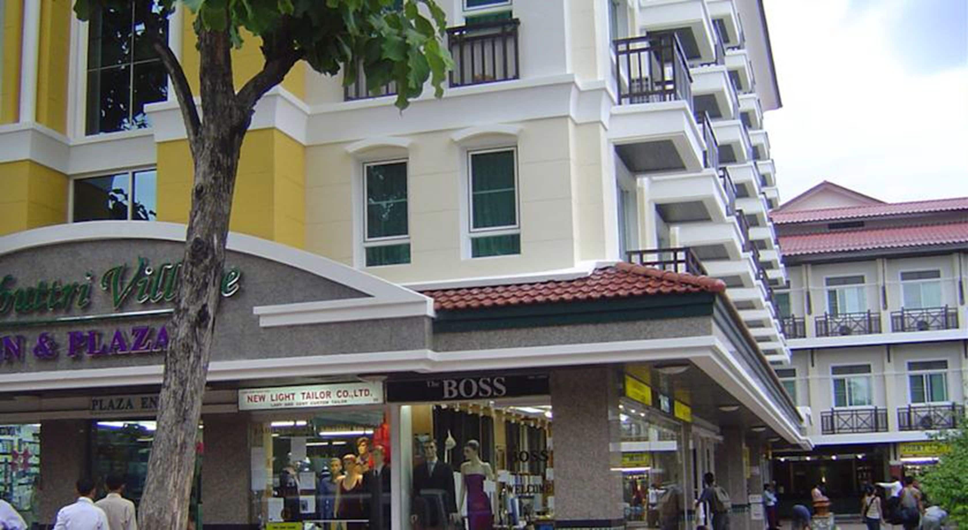 A multi-story building with a sign for 'Sutri Villa' and 'Plaza Envy'.