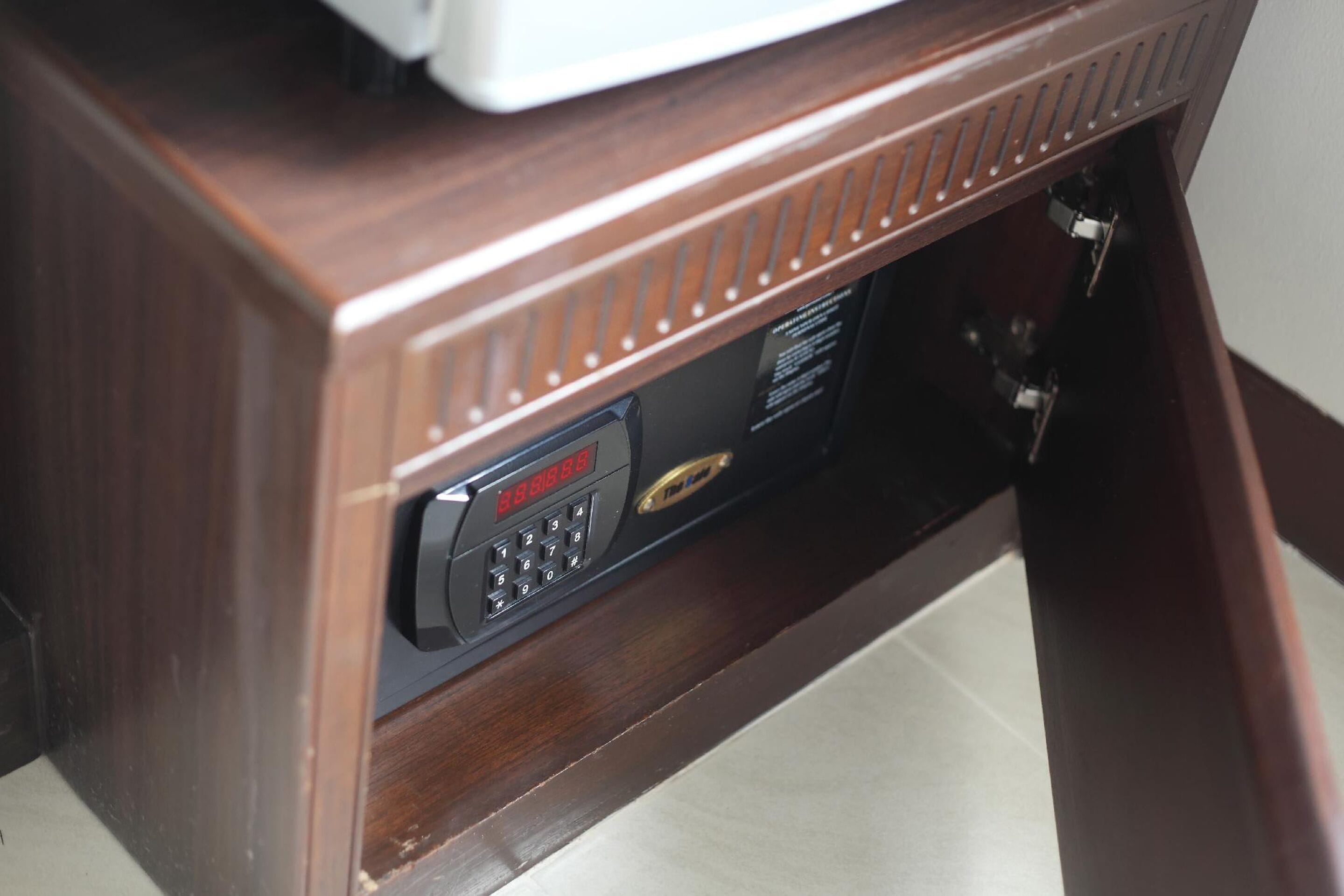 Un bureau en bois doté d’un téléphone intégré et d’un petit panneau de commande.