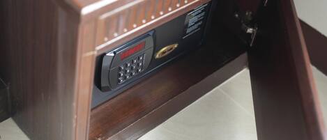 Un escritorio de madera con teléfono incorporado y un pequeño panel de control.