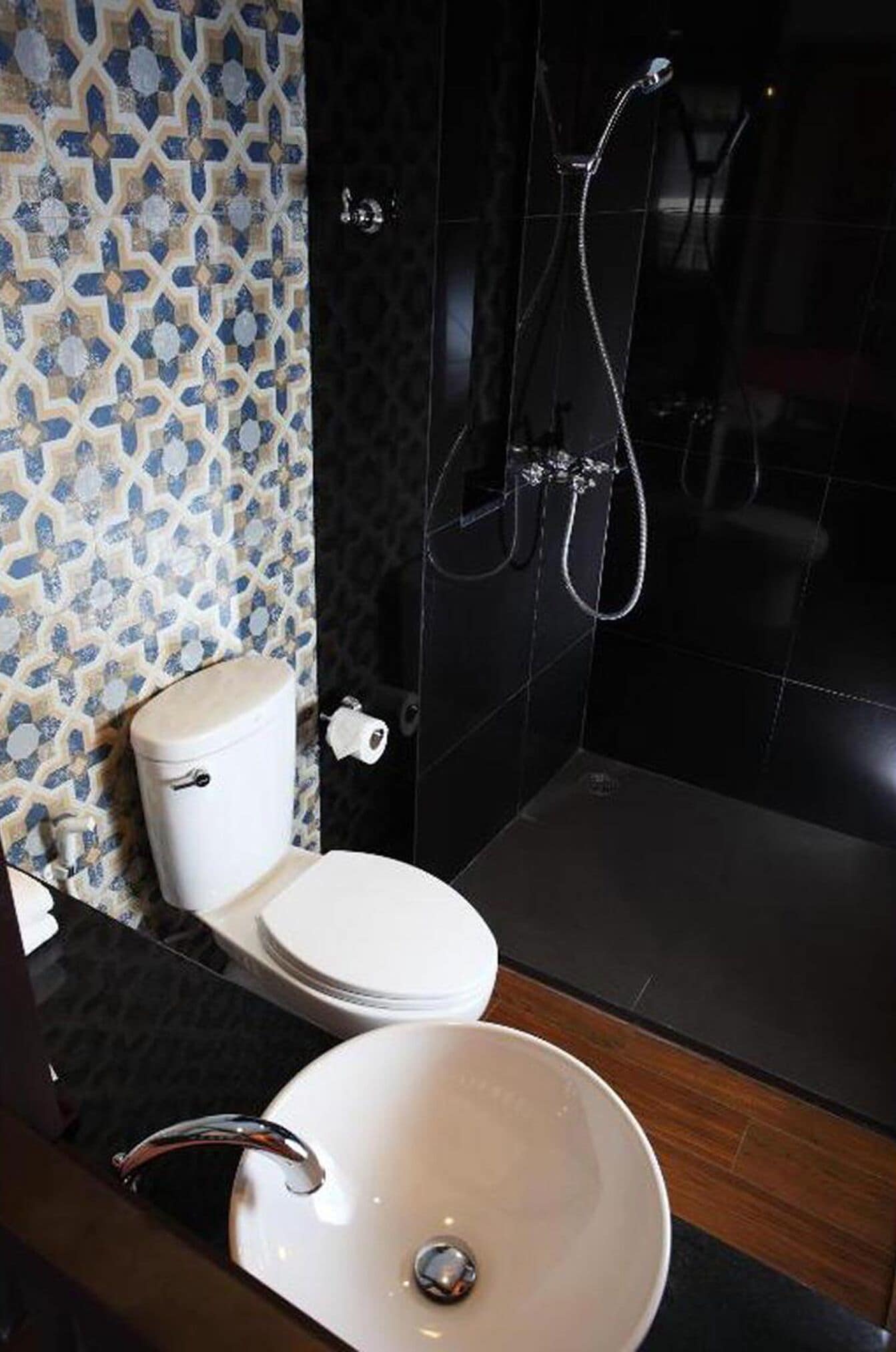 A bathroom with a toilet, sink, and shower area.