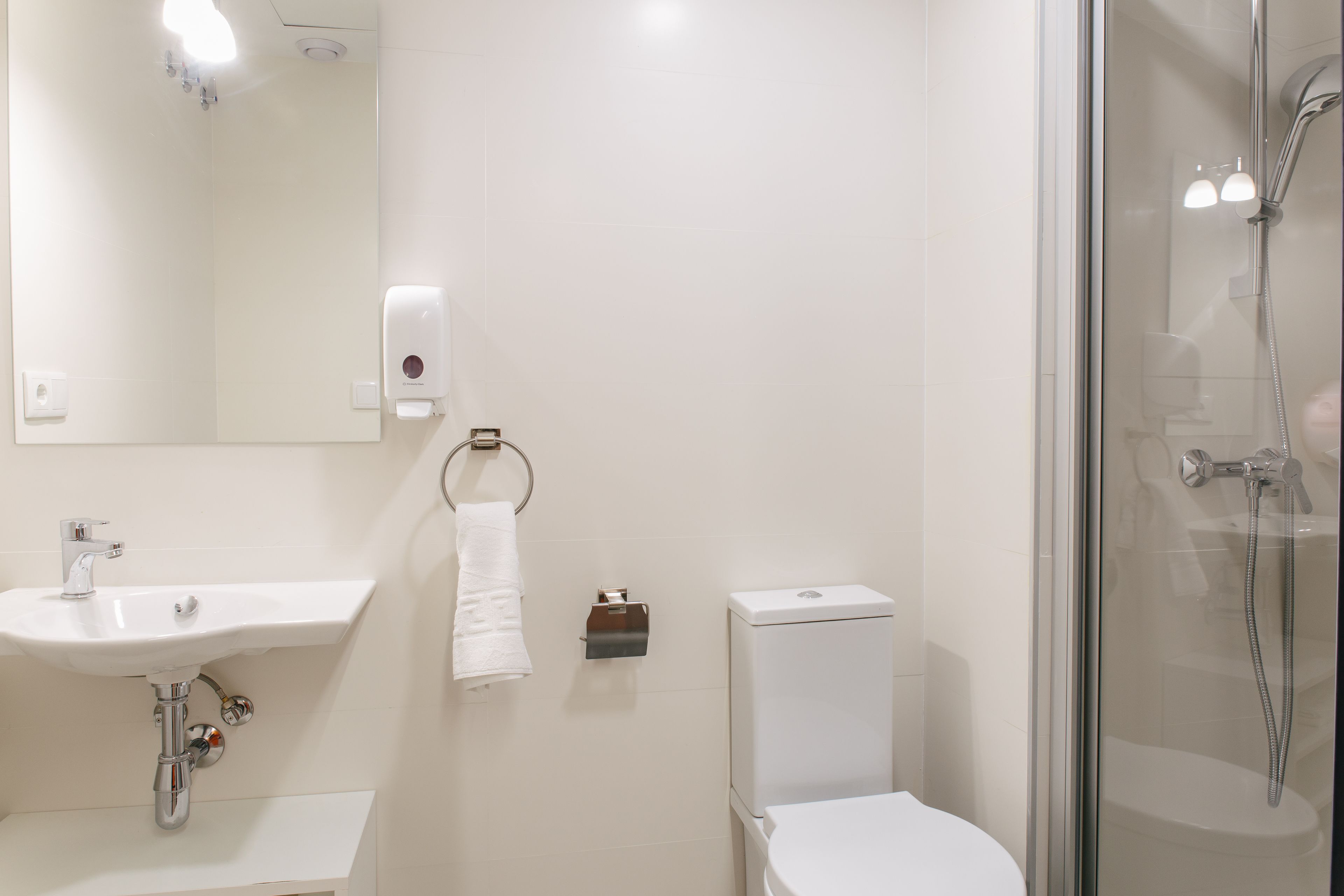 Un baño con lavamanos, inodoro y ducha.