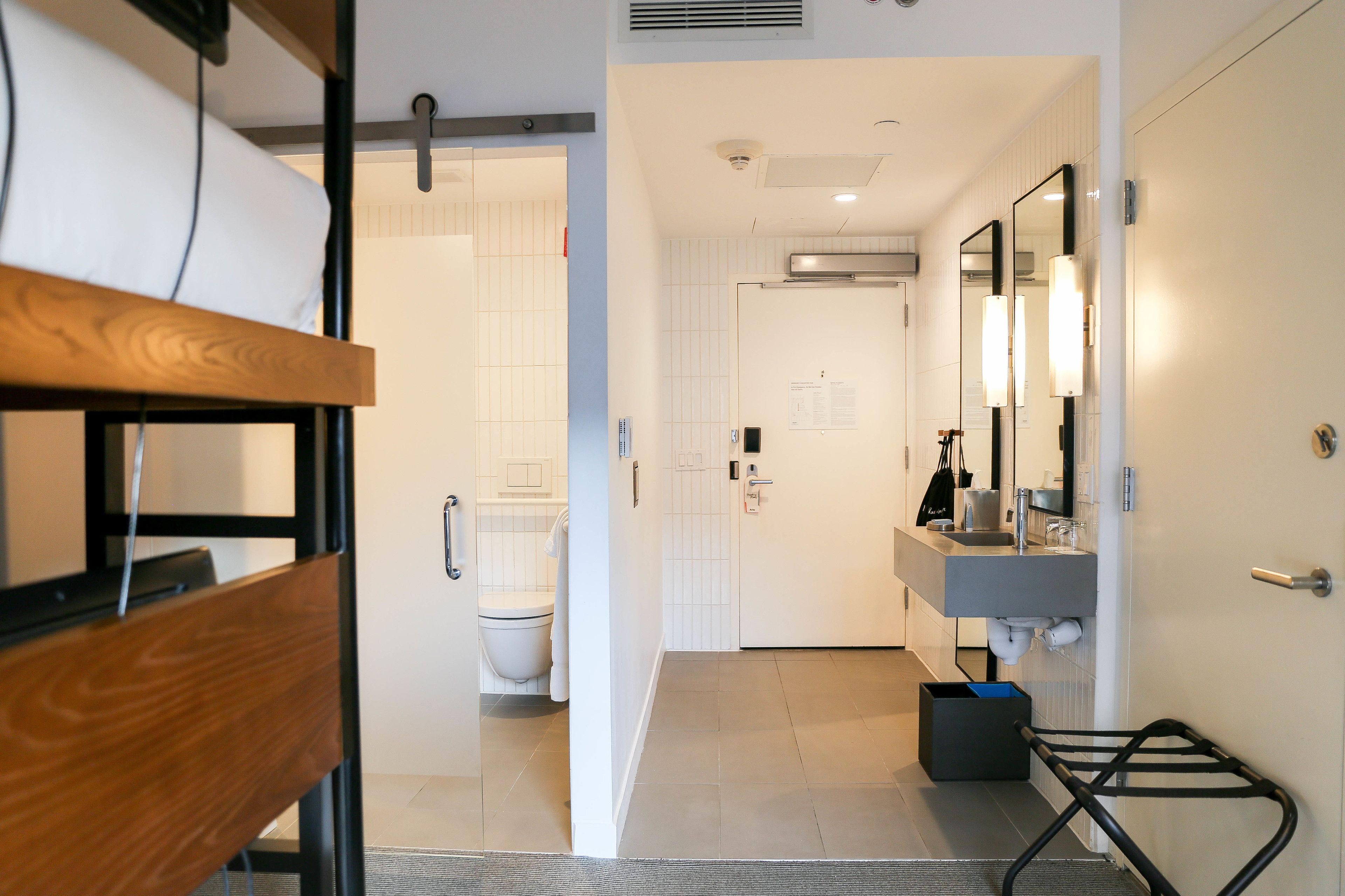 A modern bathroom with a shower, toilet, and sink.