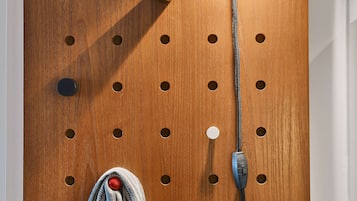 Eine Lochwand mit verschiedenen Haken und einer Pendelleuchte.