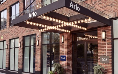 A brick building with a covered entrance labeled "Arlo."