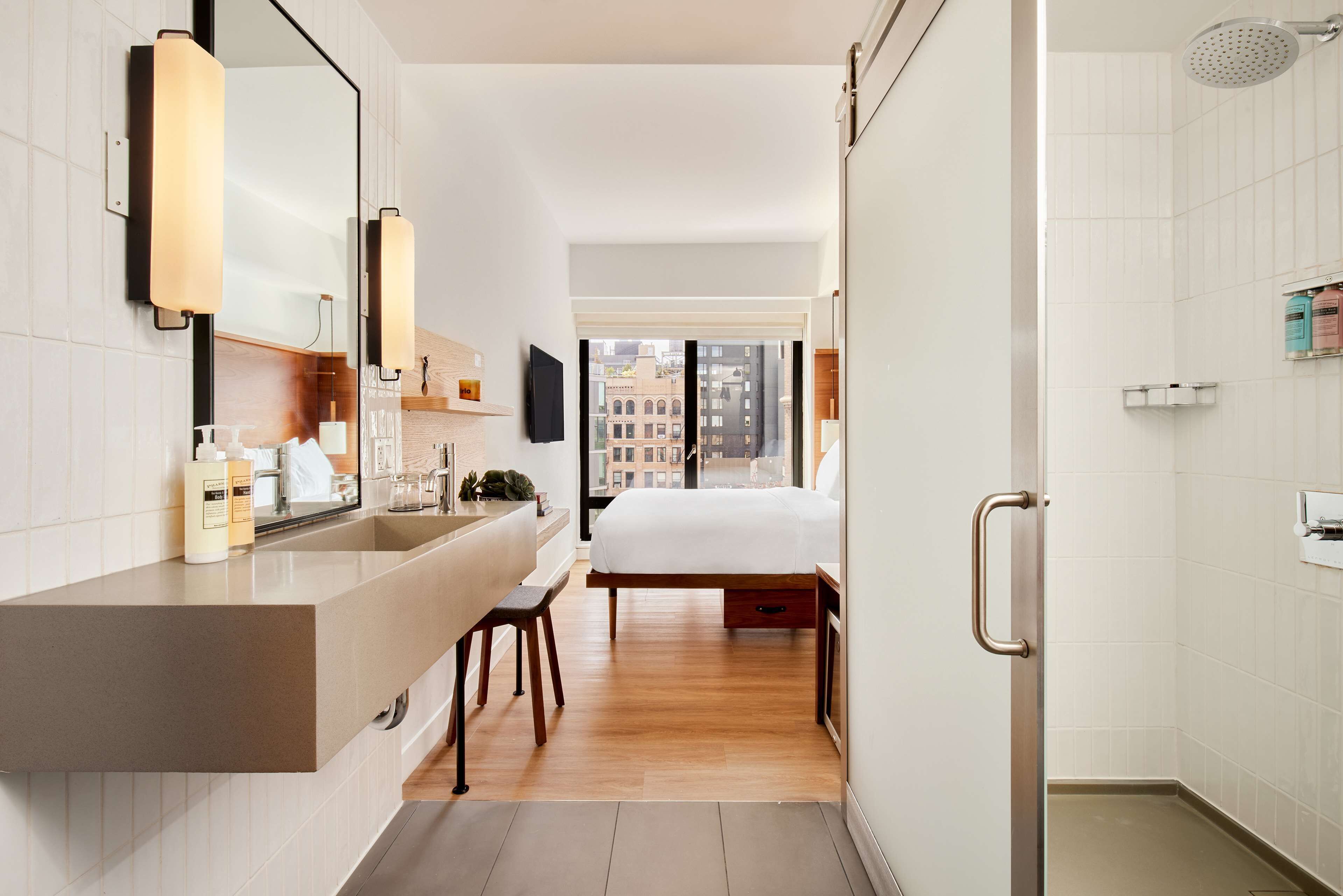 A modern bathroom with a large mirror, a sink, and a shower.