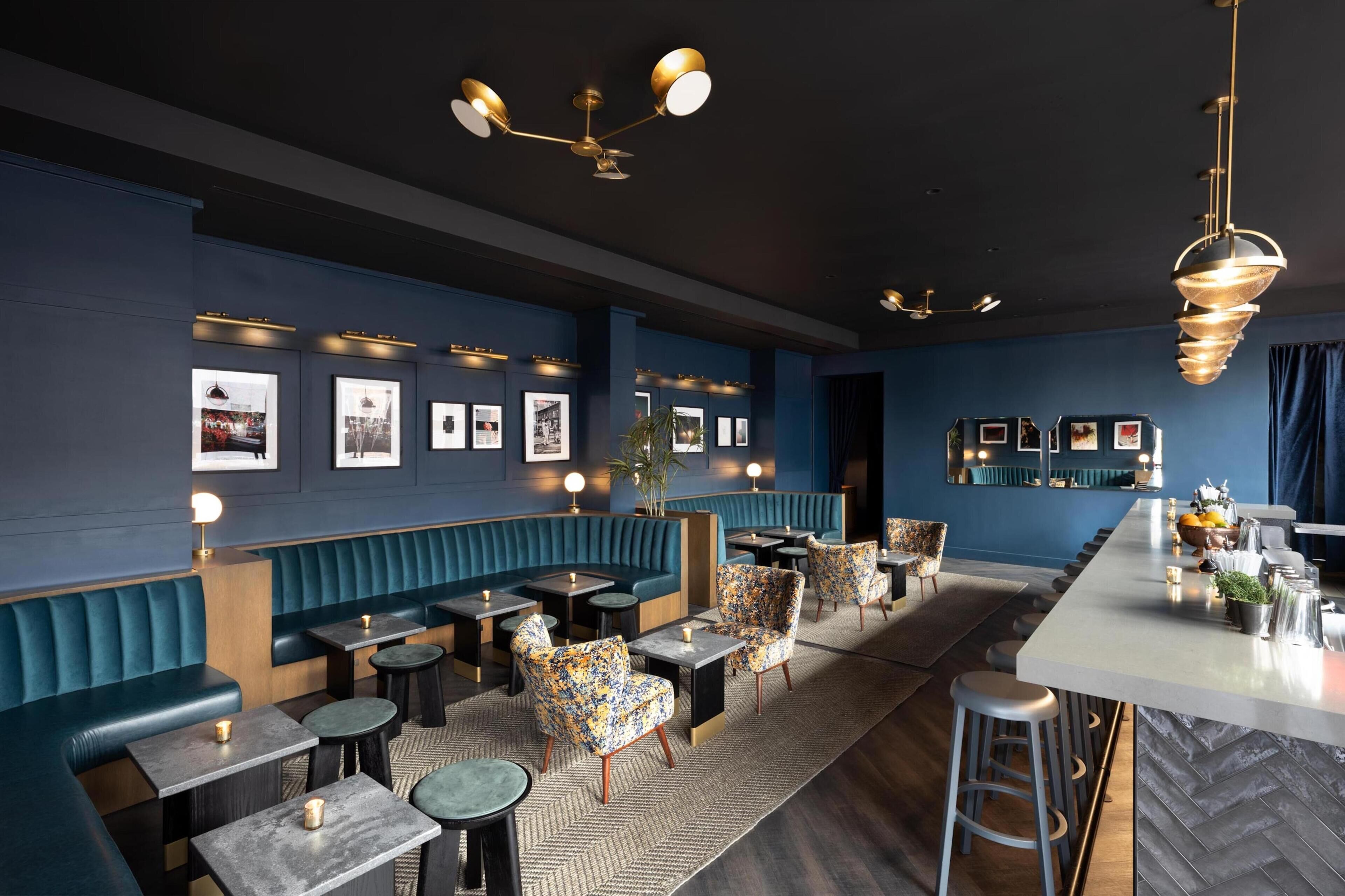 A modern restaurant interior with booths, tables, and bar seating.