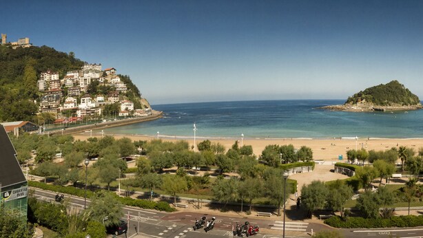 A coastal town with a beach, a hilltop with buildings, and a view of the sea. - Hotel La Galería (San Sebastián)