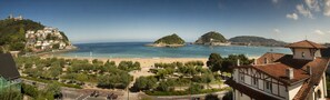 A coastal town with a beach, a hilltop with buildings, and a view of the sea. - Hotel La Galería (San Sebastián)