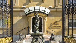 A historic building with a central fountain, statues, and a sign reading "Hotel La Galeria." - Hotel La Galería (San Sebastián)
