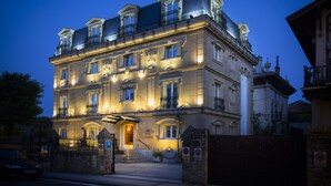 A historic building with multiple balconies, a grand entrance, and a sign indicating it is a hotel. - Hotel La Galería (San Sebastián)