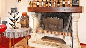 A fireplace with a brick mantel and a selection of bottles on top. - Hôtel le Pavillon de Rouen (Franqueville-Saint-Pierre)
