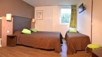 A room with two beds, a desk, a chair, a TV, and a window with curtains.