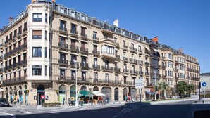 Un edificio de varios pisos con un estilo arquitectónico clásico, que cuenta con balcones y ventanas grandes.