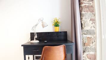 Un espacio de trabajo moderno con escritorio, silla y lámpara.