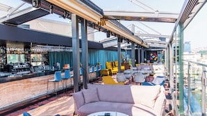 A rooftop bar with a bar counter, seating area with sofas and chairs, and a view of the cityscape. - Courtyard by Marriott Sarajevo (Sarajevo)