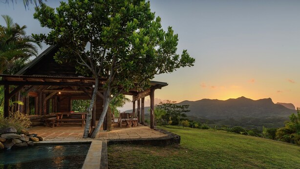 A wooden gazebo with a pool, surrounded by lush greenery and a view of distant mountains. - La Vieille Cheminee (Chamarel)