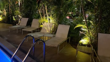 An indoor pool area with lounge chairs and a pool ladder.