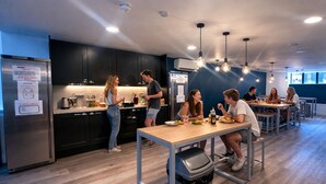 A modern kitchen with stainless steel appliances, wooden countertops, and pendant lighting. - Smart Camden Inn Hostel (London)