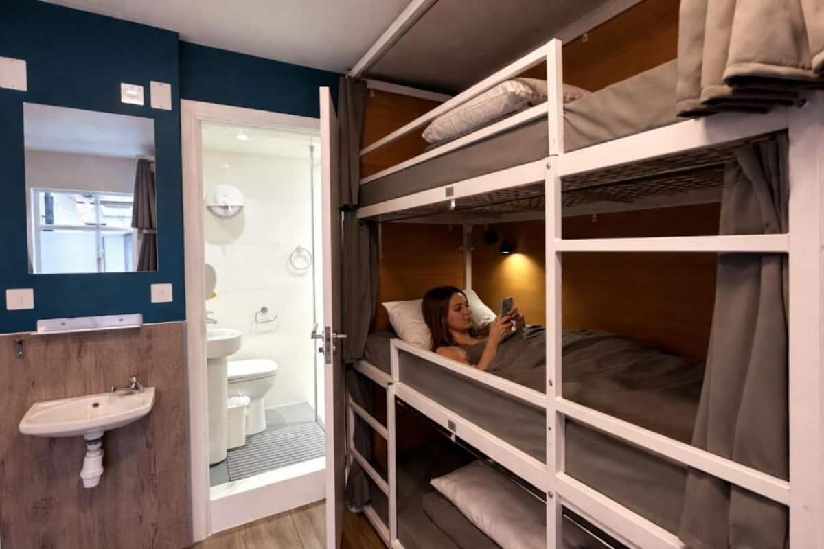 A bunk bed room with a sink and a mirror.