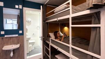 A bunk bed room with a sink and a mirror.