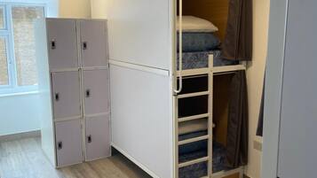 Una habitación compacta con literas, armario empotrado y ventana.