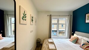 A hotel room with a bed, a window, and wall art. - Smart Camden Inn Hostel (London)