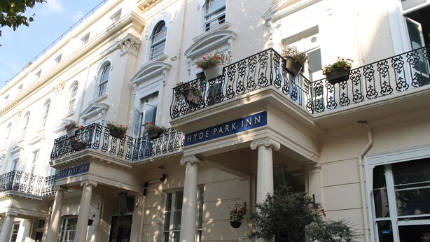 A classical building with a sign reading "Hyde Park Inn".