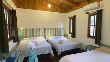 A room with two beds, wooden ceiling, and a small table with chairs.