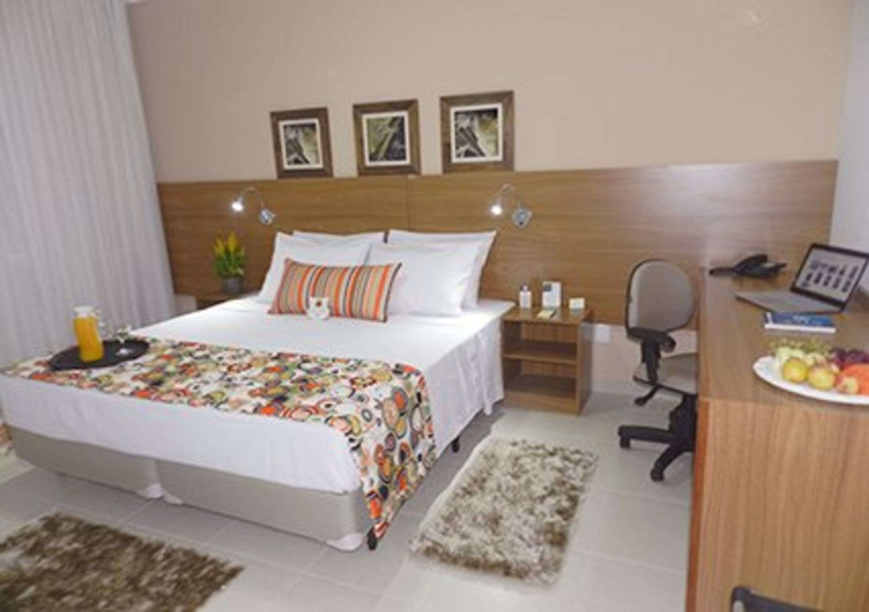 Una habitación de hotel con cama, mesita de noche, escritorio y silla.