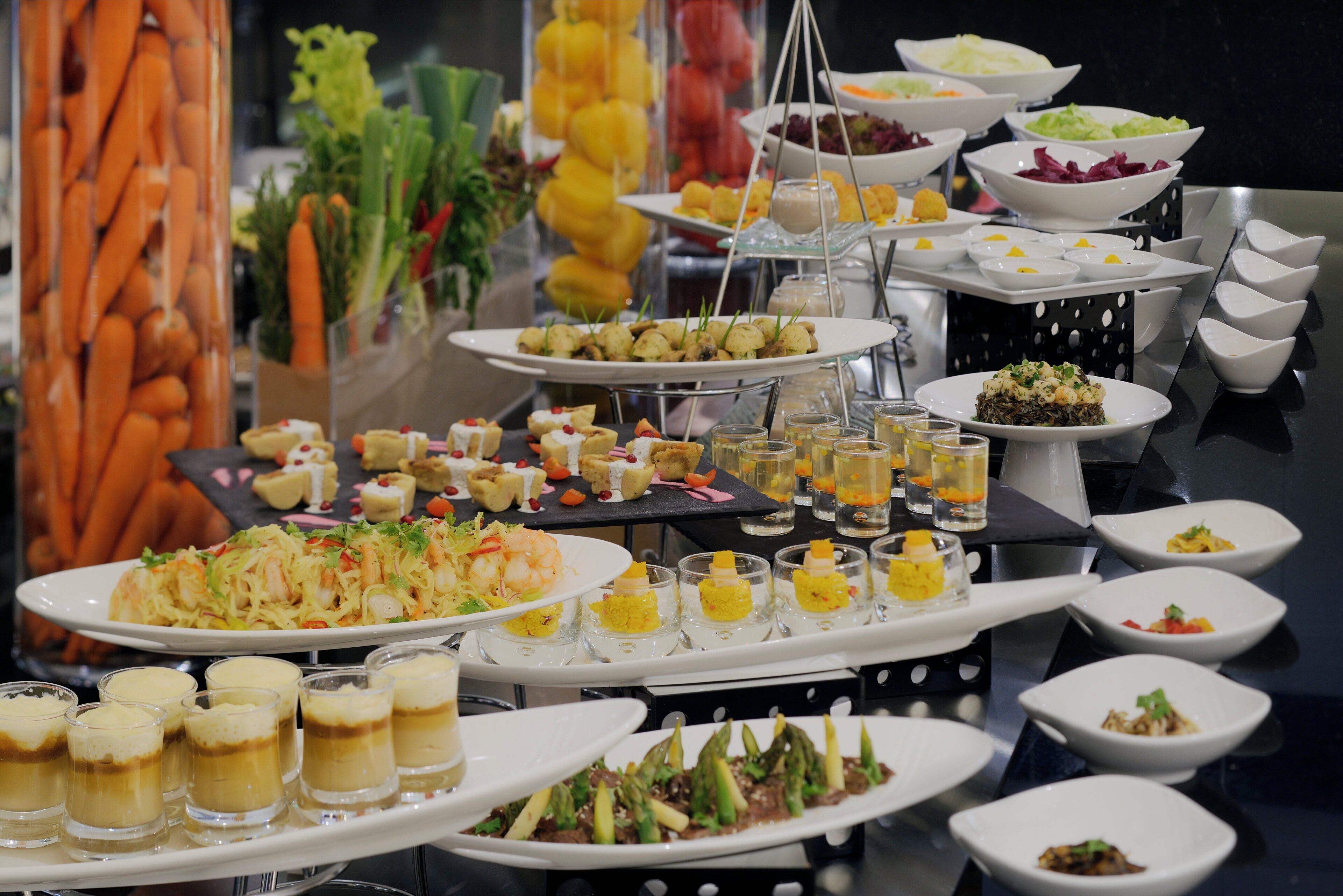 Un buffet proposant une variété de plats et de boissons, notamment des fruits de mer, des salades et des desserts.