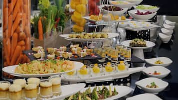 Un buffet proposant une variété de plats et de boissons, notamment des fruits de mer, des salades et des desserts.