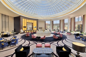 A spacious lobby with a central fountain, seating areas, and a large glass ceiling. - voco Riyadh by IHG (Riyadh)