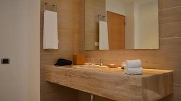 Un baño moderno con lavamanos de mármol, un espejo y un perchero para toallas.