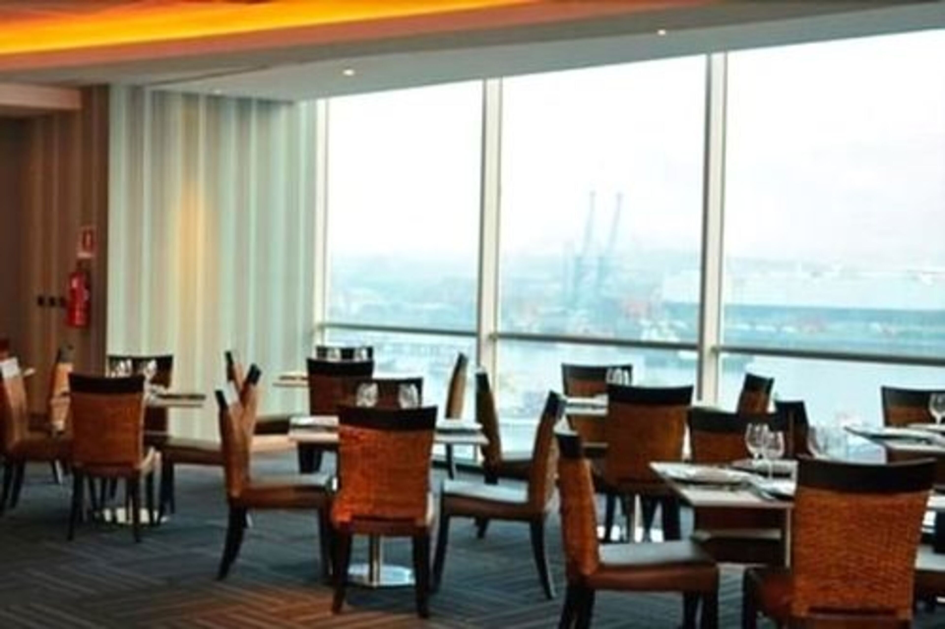 Un restaurante con vistas al horizonte urbano a través de amplias ventanas.