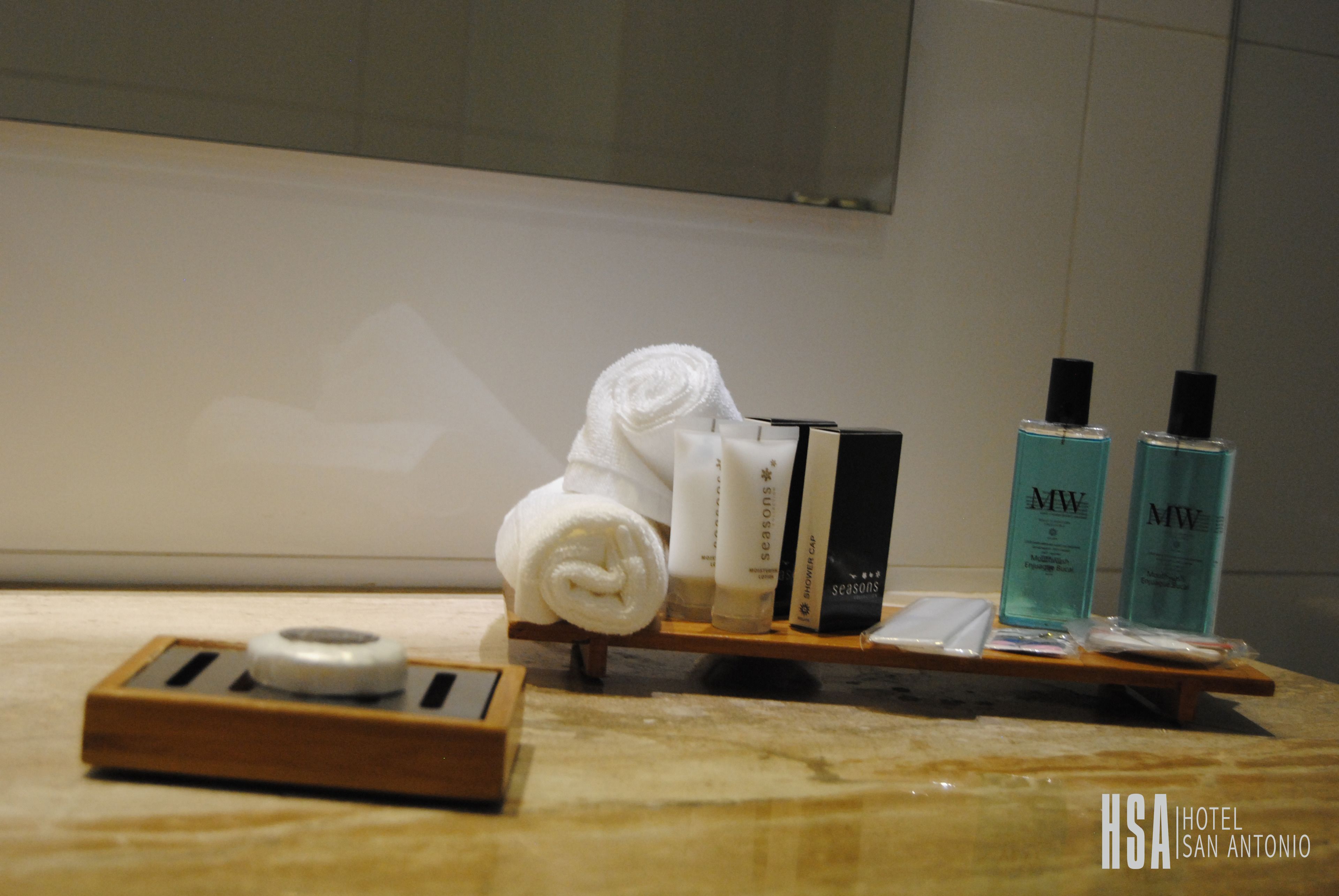 A hotel room's amenities area with toiletries, a towel, and a tray.