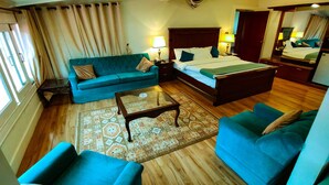 Een hotelkamer met een bed, een bank, een bijzettafeltje en een bureau.