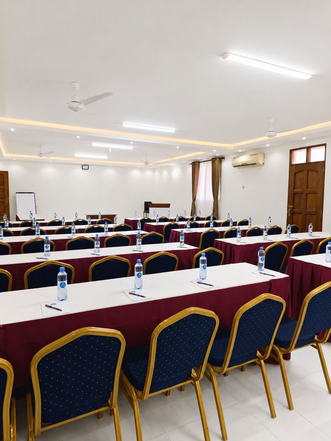 A conference room with tables, chairs, and water bottles.