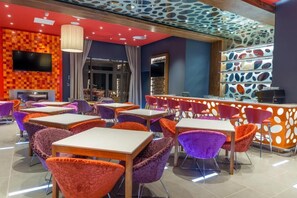 Un restaurante moderno con asientos coloridos y un diseño de techo singular.