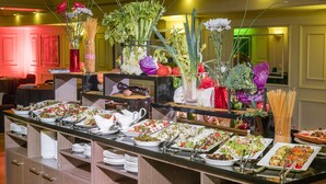 A buffet setup with various food items and fresh vegetables displayed on a counter. - Hotel Frontera Plaza (Temuco)
