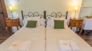A double bed with white linens, two green pillows, and two bedside tables with lamps. - Posada Real Quinta San José (Piedralaves)